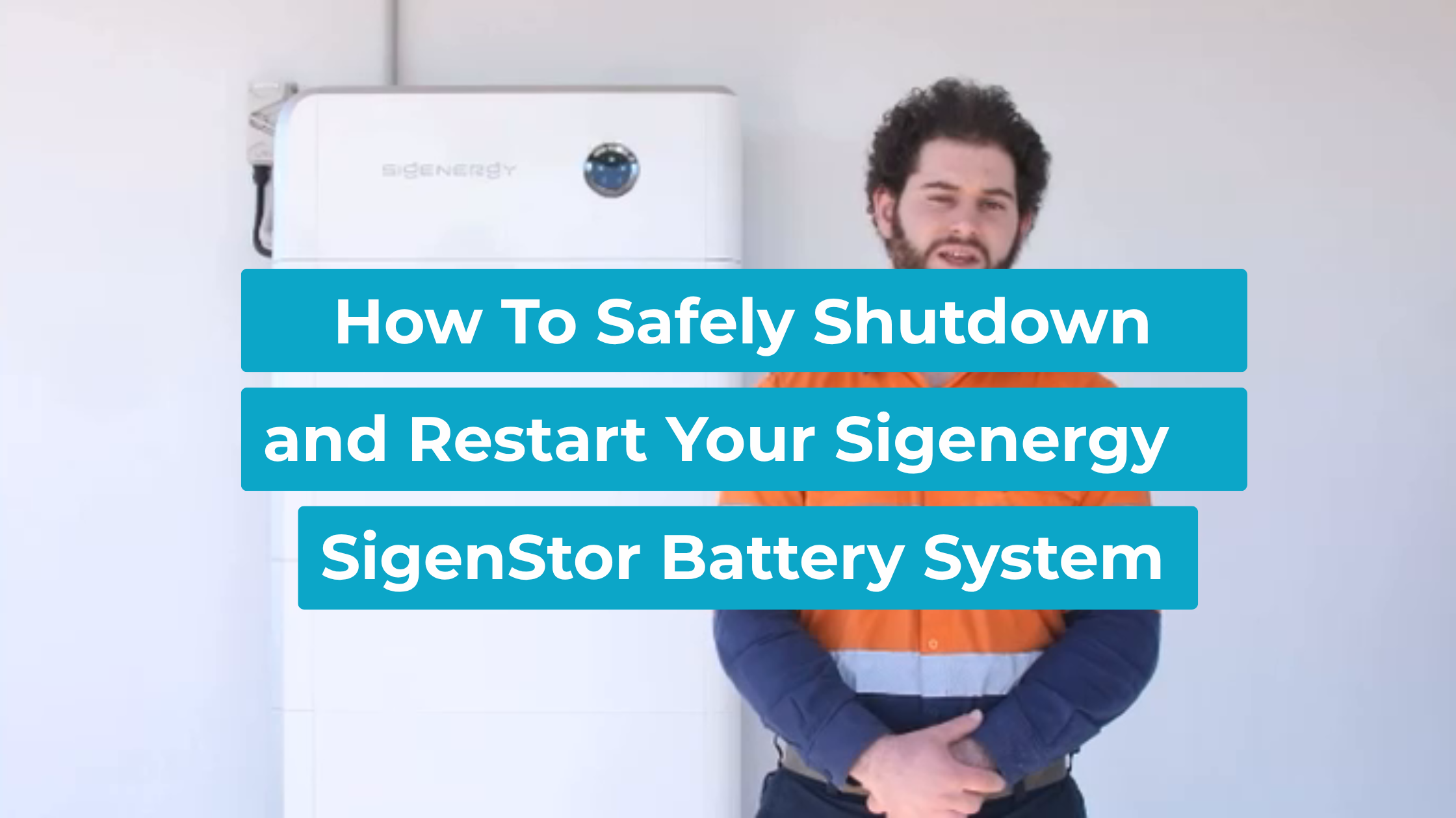 Lenergy technician Ziad standing beside a wall-mounted Sigenergy SigenStor battery system, ready to shut down and restart it.