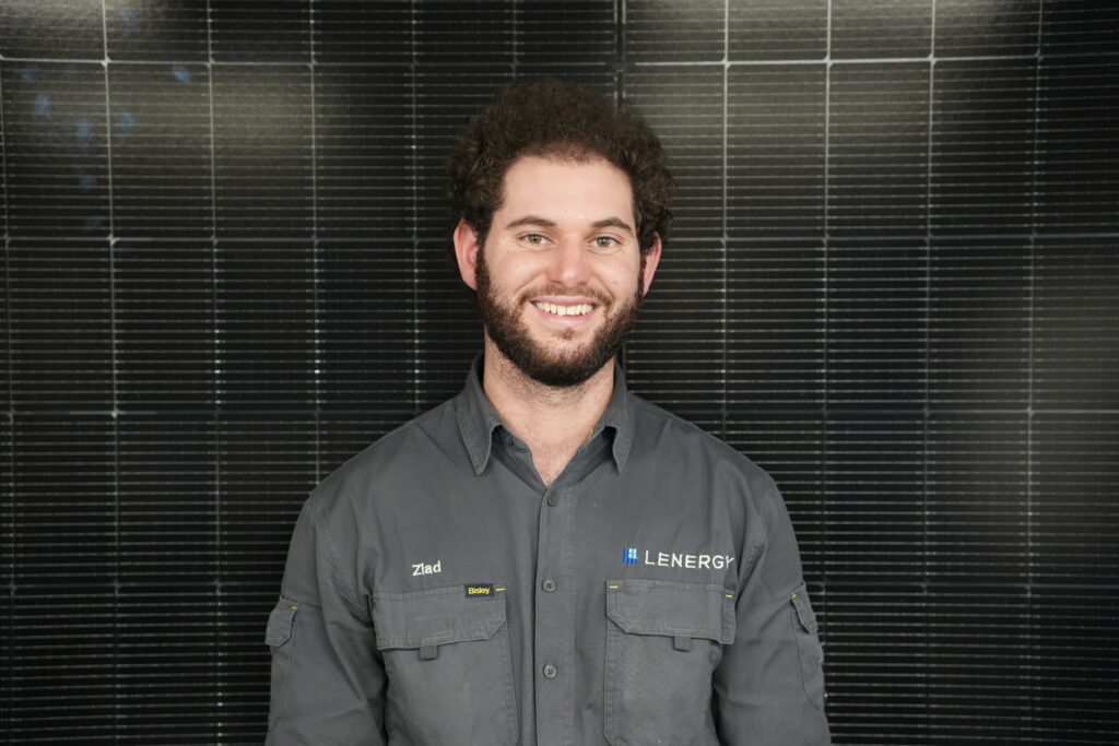 Lenergy staff member, Ziad standing in front of solar panels