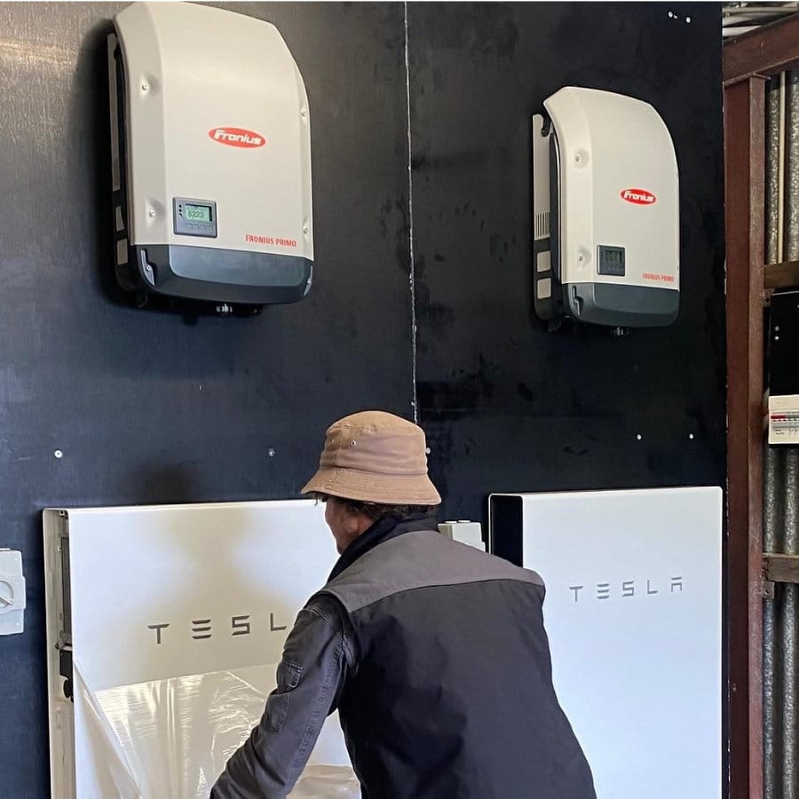 Lenergy staff member installing a Tesla Battery for a home located in the Southern Highlands