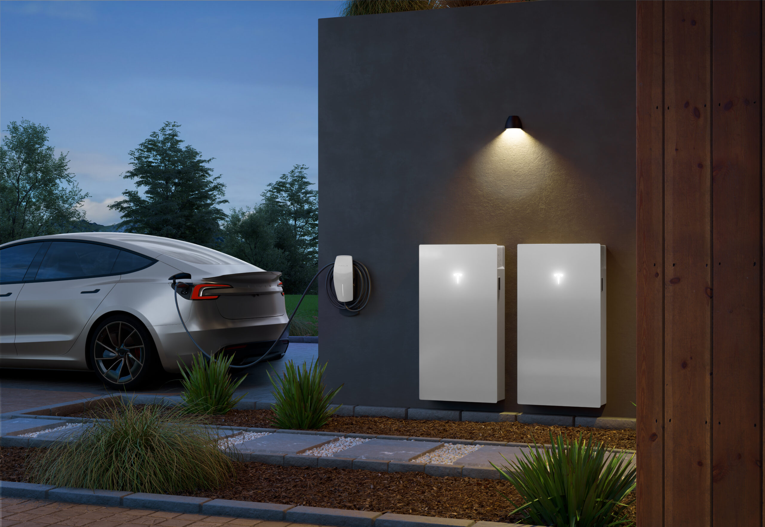 Tesla Powerwall 3 home battery installed outdoors on a wall beside a modern house with solar panels and greenery in the background.