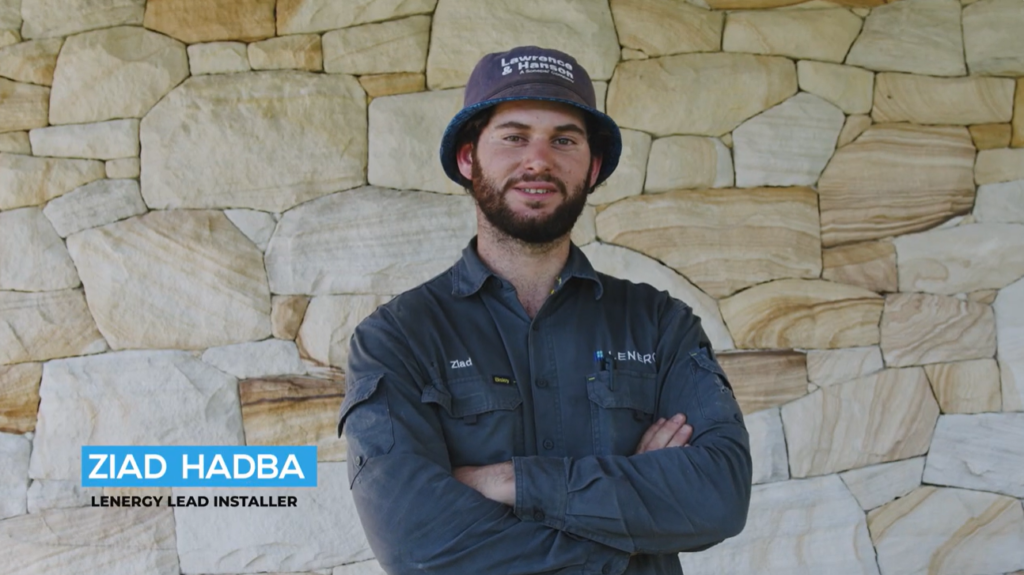 Ziad Hadba, Lenergy lead installer, standing in front of a sandstone wall at the Kangaroo Valley site