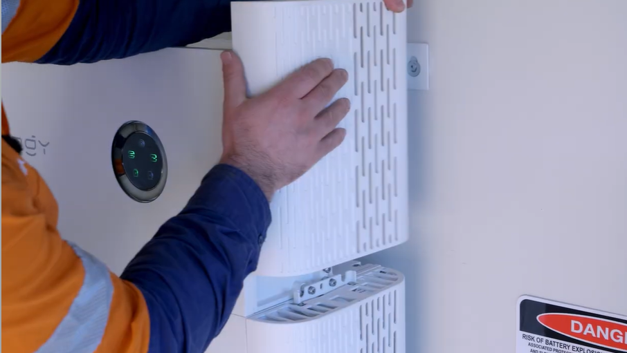 Hands lifting the right-hand side cover off a SigenStor to reach the QR code and reconnect the Sigenergy SigenStor to Wi-Fi.
