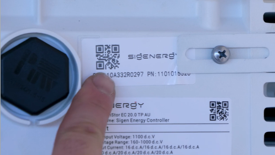 Finger pointing to the larger top QR code on the SigenStor, the one to scan when you reconnect the Sigenergy SigenStor to Wi-Fi.