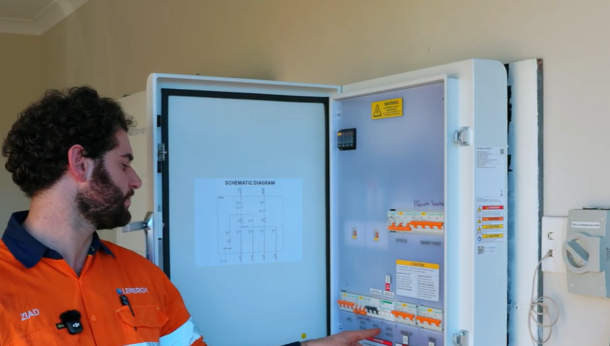 Lenergy technician Ziad at the open gateway locating the circuit breaker to reset a SigenStor that lost its Wi-Fi connection.
