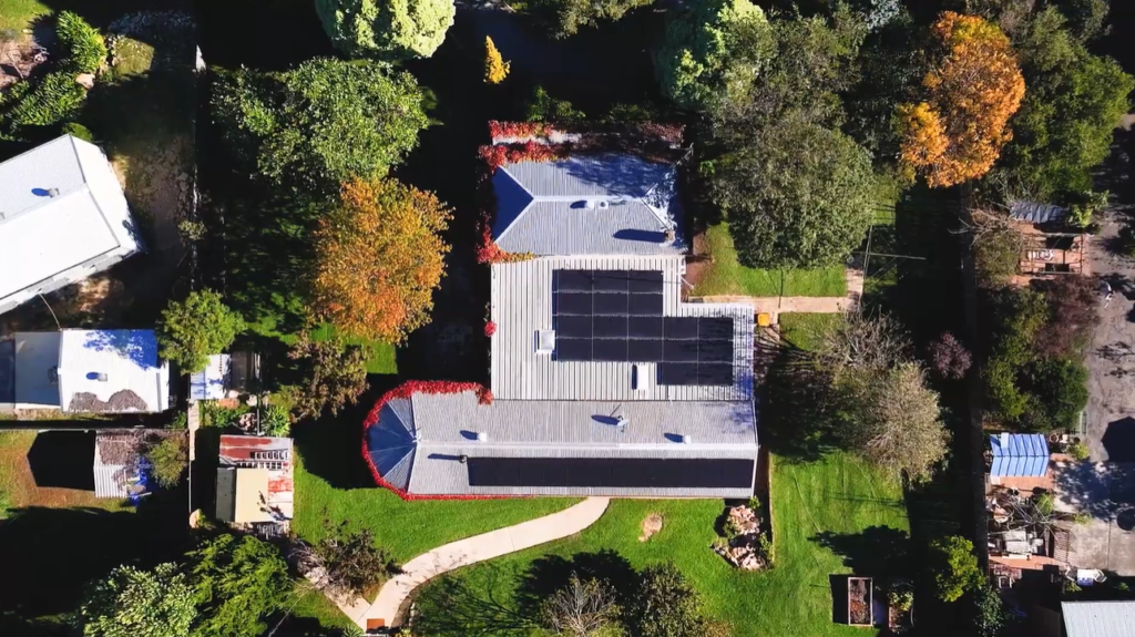 Aerial view of Helen's home solar installation, showing panels across the roof of her Southern Highlands property surrounded by autumn trees.
